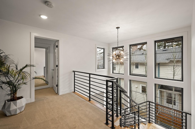 corridor with carpet, recessed lighting, an upstairs landing, a chandelier, and baseboards