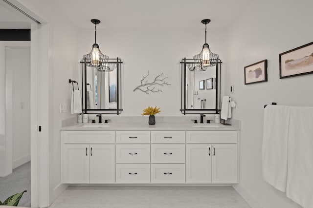 full bathroom featuring baseboards, double vanity, a sink, and a notable chandelier