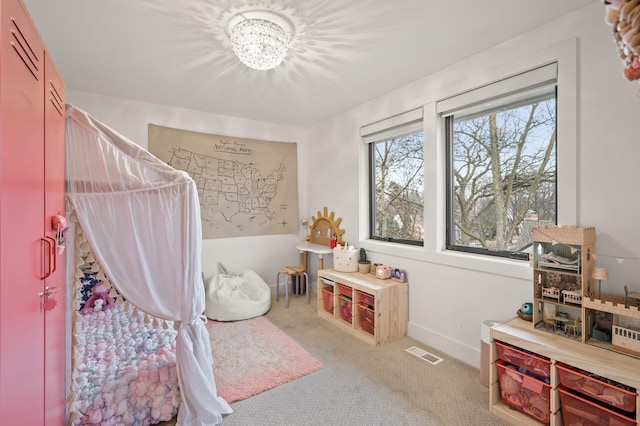 bedroom with carpet, visible vents, a chandelier, and baseboards