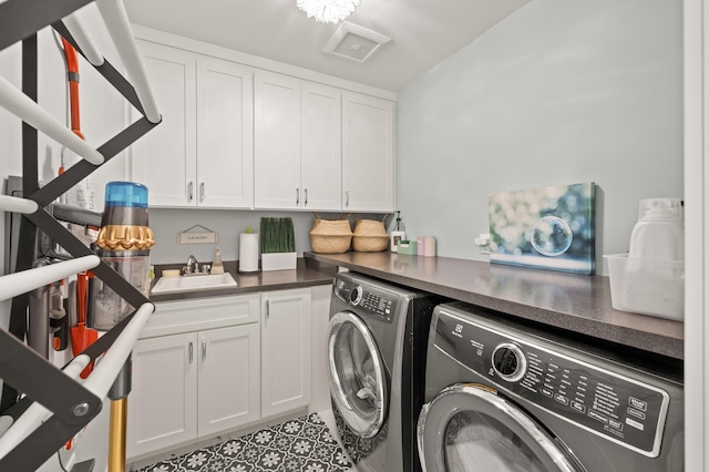 washroom featuring cabinet space, a sink, visible vents, and washing machine and clothes dryer