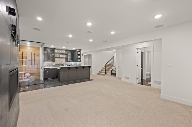 kitchen featuring visible vents, glass insert cabinets, light countertops, backsplash, and recessed lighting