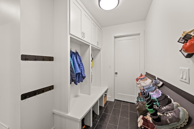 mudroom with dark tile patterned flooring