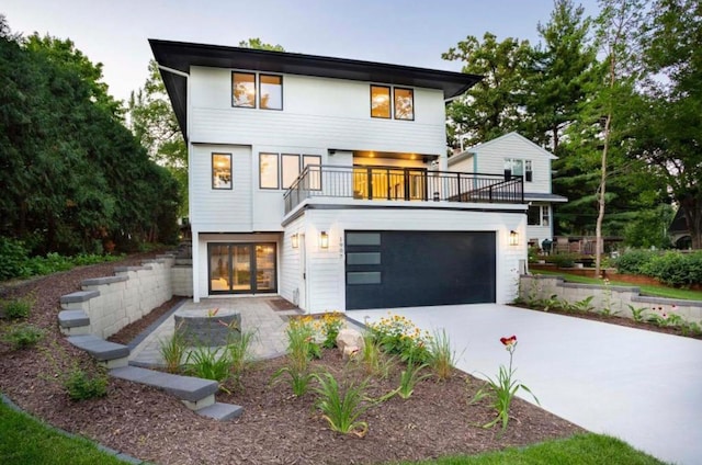 view of front of home with driveway and a balcony