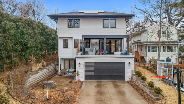 view of front facade featuring a garage, driveway, and solar panels