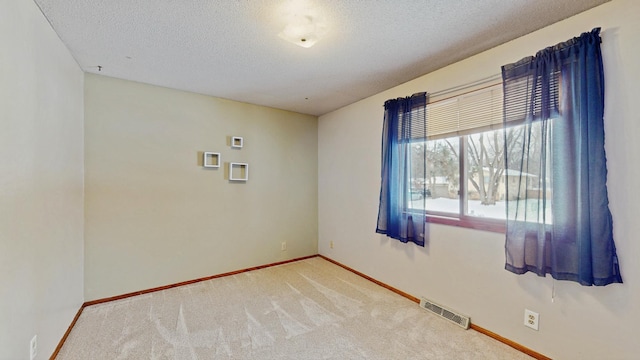 carpeted spare room with a textured ceiling