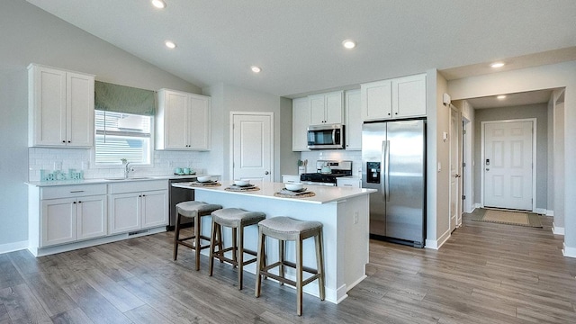 kitchen with appliances with stainless steel finishes, a center island, and white cabinets