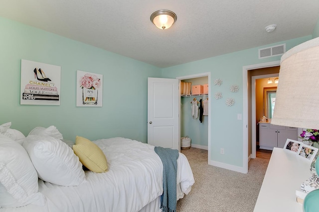 carpeted bedroom with a closet, a spacious closet, and a textured ceiling