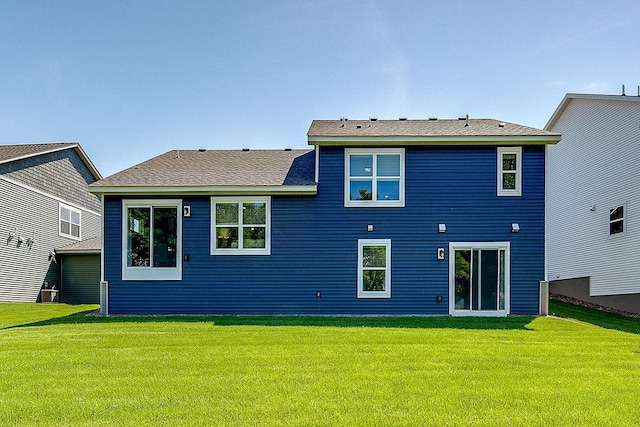 rear view of property featuring a lawn