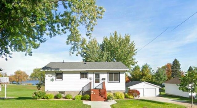 view of front facade with a garage, an outdoor structure, and a front yard