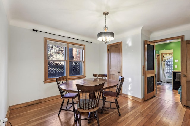 dining space with wood-type flooring and a chandelier