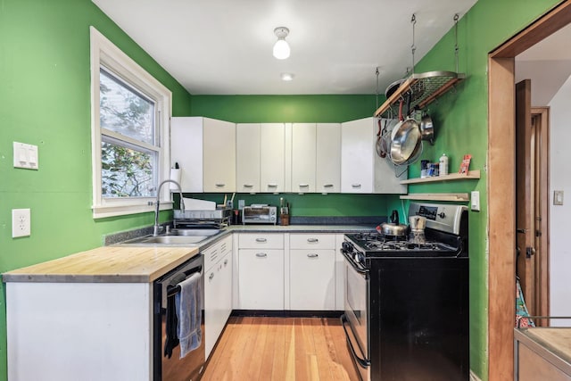 kitchen with stainless steel range with gas cooktop, dishwasher, white cabinetry, sink, and light hardwood / wood-style floors