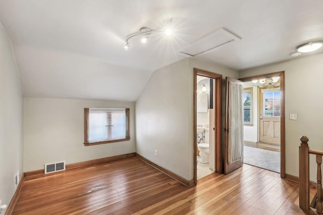 bonus room with lofted ceiling and wood-type flooring