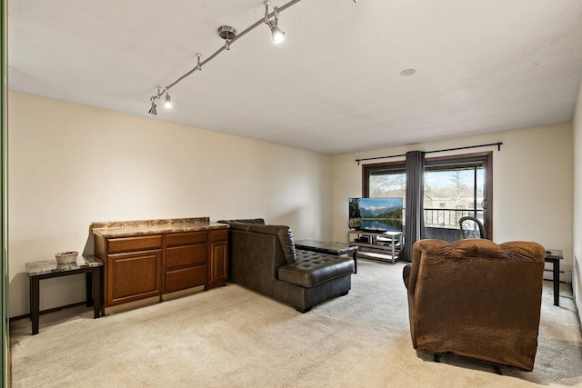 carpeted living room featuring track lighting