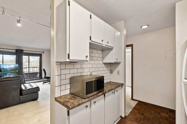 kitchen featuring white cabinetry, parquet floors, a textured ceiling, and decorative backsplash