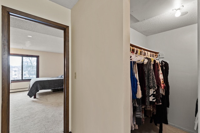 walk in closet with a baseboard heating unit and carpet