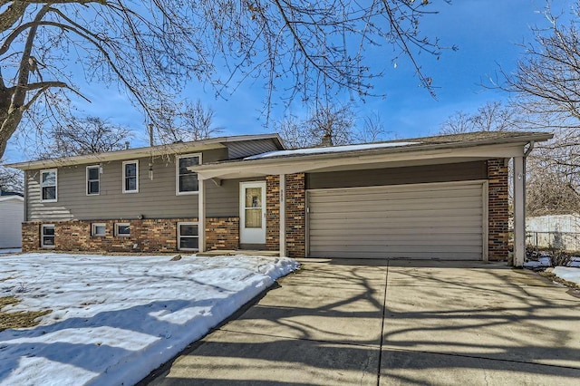 tri-level home featuring brick siding, driveway, and a garage