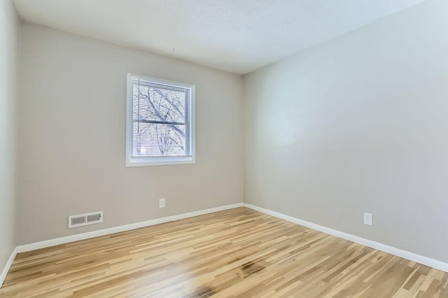 unfurnished room with light wood-style flooring, baseboards, and visible vents