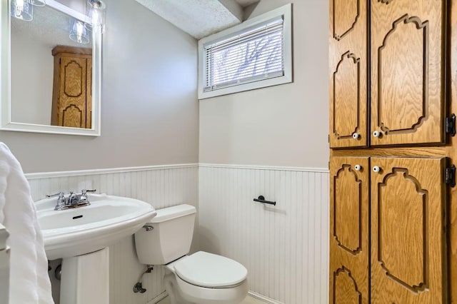 bathroom with a wainscoted wall and toilet