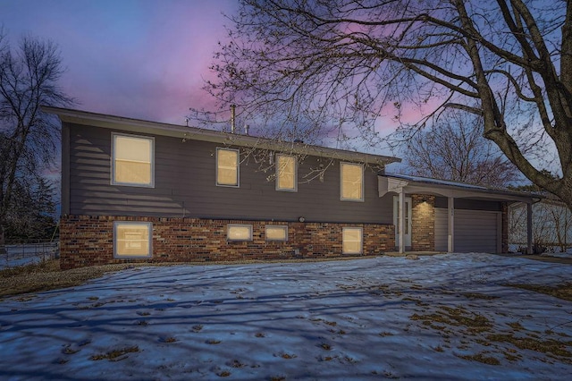 tri-level home featuring brick siding, driveway, and a garage