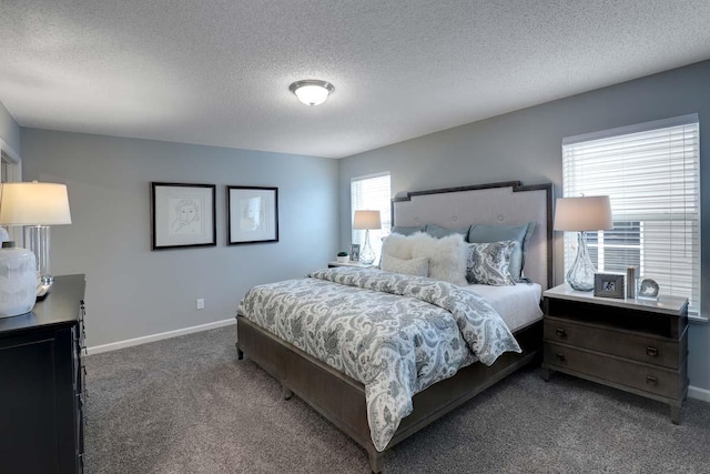 bedroom featuring a textured ceiling and dark colored carpet