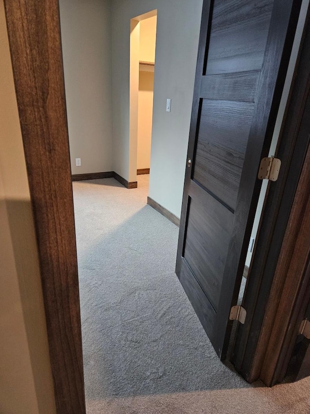 hallway featuring light colored carpet