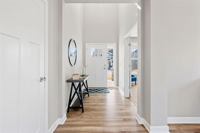 foyer entrance with light wood-type flooring and baseboards