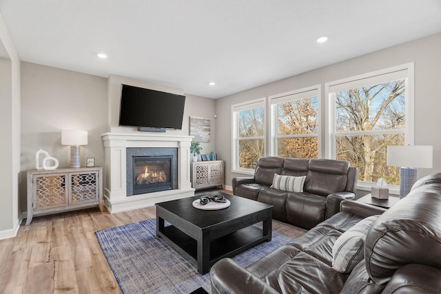 living room featuring recessed lighting, baseboards, and light wood finished floors