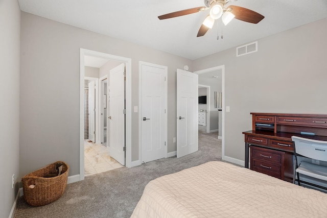 bedroom featuring visible vents, a ceiling fan, connected bathroom, baseboards, and light colored carpet