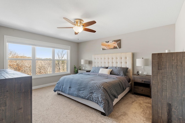 carpeted bedroom with ceiling fan and baseboards