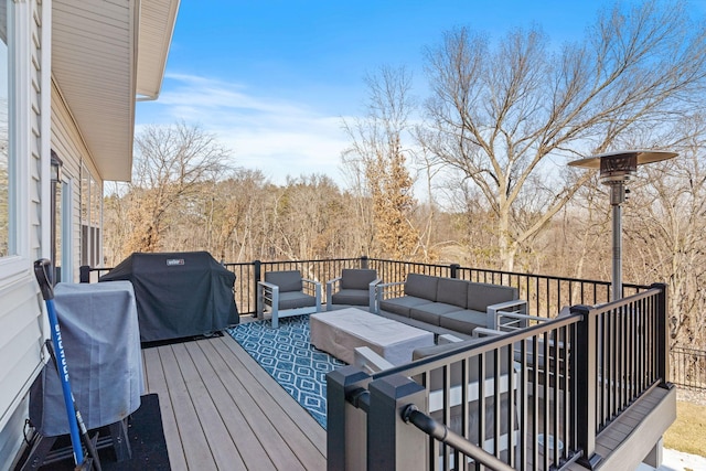 wooden terrace with grilling area, an outdoor hangout area, and a wooded view