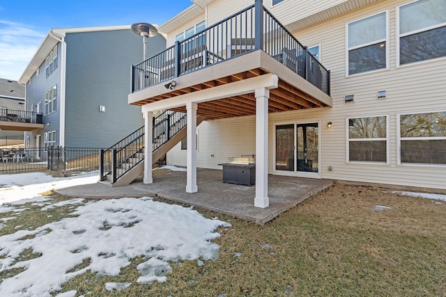 snow covered house with a patio area and stairs