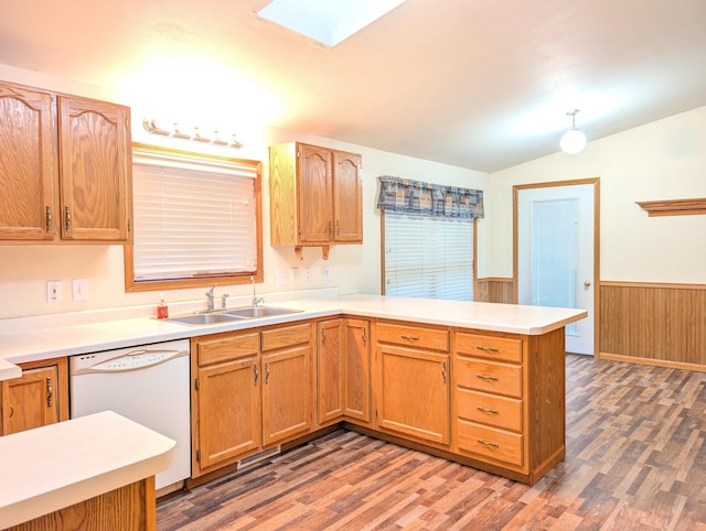 kitchen featuring lofted ceiling with skylight, decorative light fixtures, dishwasher, sink, and kitchen peninsula