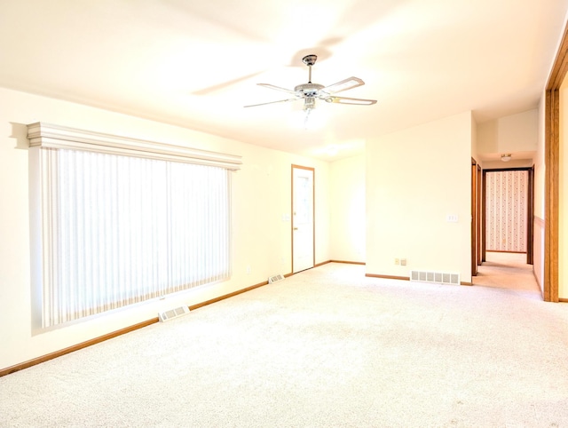 spare room with ceiling fan and light colored carpet