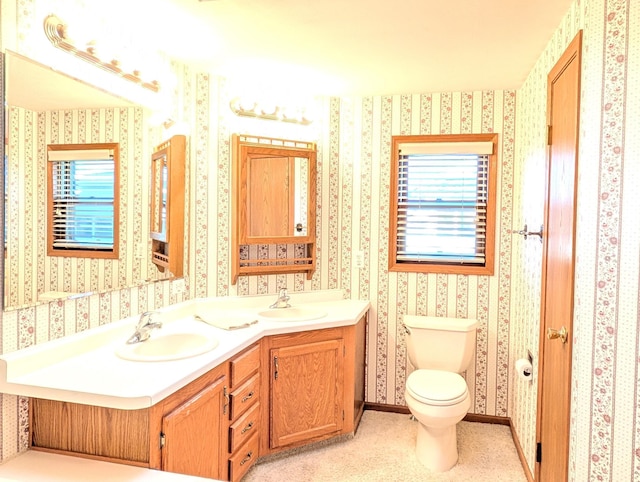 bathroom with vanity, toilet, and a healthy amount of sunlight