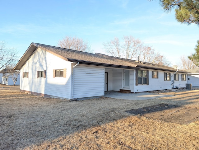 view of front of house featuring a patio area, a front yard, and central air condition unit