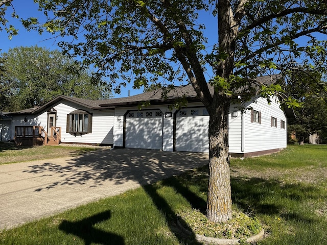 501 Lac Qui Parle Ave N, Canby, MN 56220 - view of side of property featuring concrete driveway, an attached garage, a deck, and a lawn