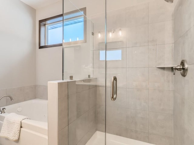 bathroom featuring shower with separate bathtub