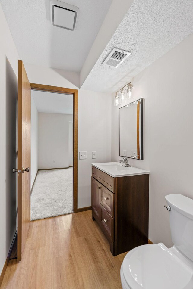 10 94th Cir NW Unit 201, Coon Rapids, MN 55448 - bathroom with wood finished floors, toilet, and vanity