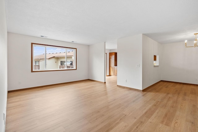 10 94th Cir NW Unit 201, Coon Rapids, MN 55448 - unfurnished room featuring a chandelier, light wood-style floors, and baseboards