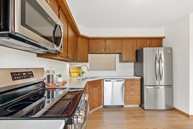 10 94th Cir NW Unit 201, Coon Rapids, MN 55448 - kitchen featuring appliances with stainless steel finishes, a sink, brown cabinetry, and light countertops