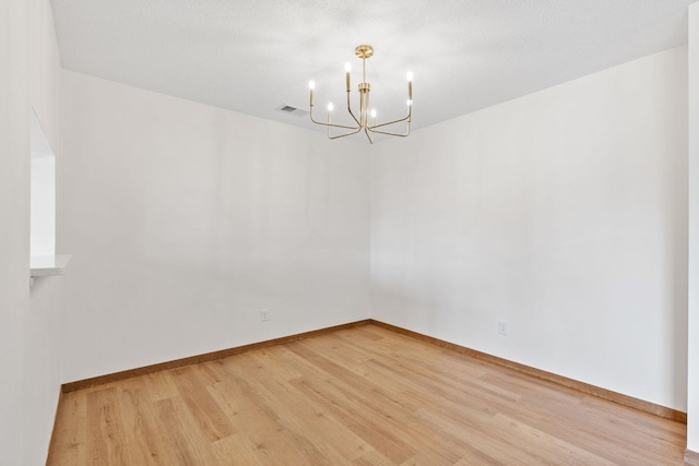 10 94th Cir NW Unit 201, Coon Rapids, MN 55448 - empty room featuring a chandelier, light wood-type flooring, and baseboards