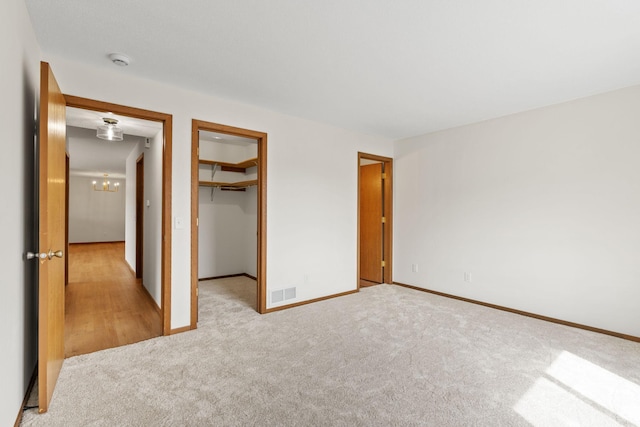 10 94th Cir NW Unit 201, Coon Rapids, MN 55448 - unfurnished bedroom with light carpet, baseboards, a spacious closet, and a closet