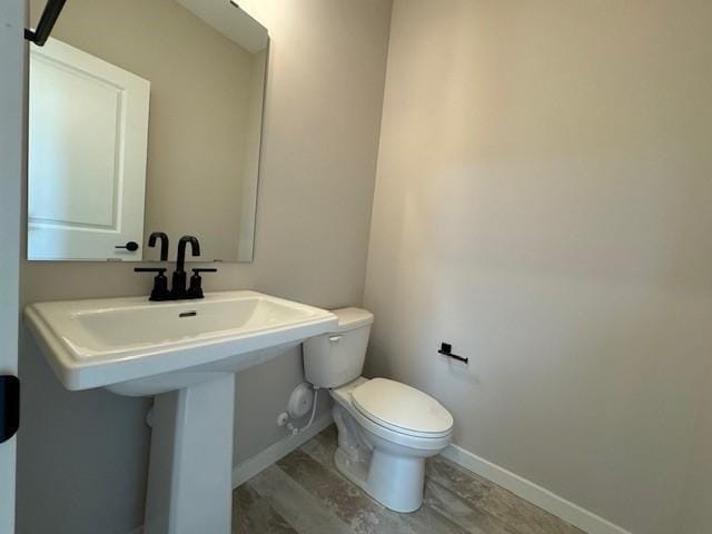 bathroom featuring sink, hardwood / wood-style flooring, and toilet