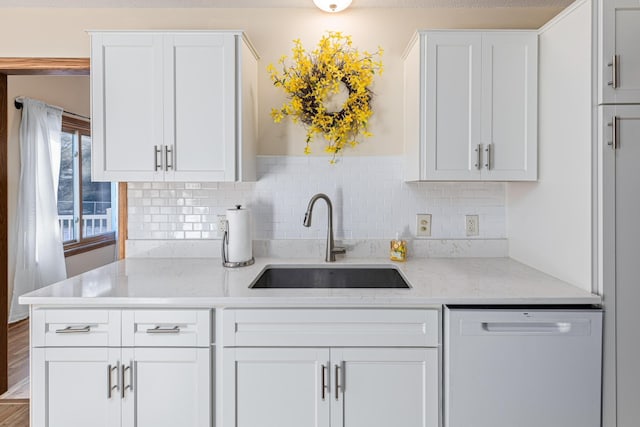 kitchen with white cabinetry, light stone countertops, sink, and white dishwasher