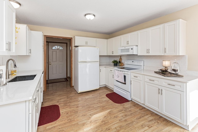 kitchen featuring sink, white appliances, light hardwood / wood-style floors, and white cabinets