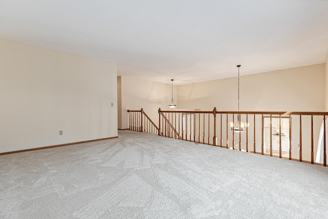 spare room with an inviting chandelier and carpet