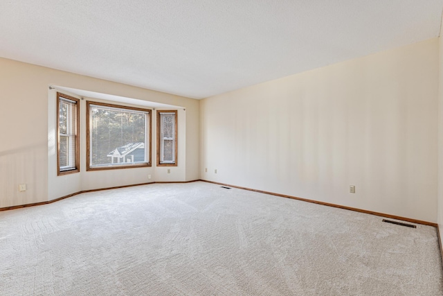 carpeted spare room with a textured ceiling