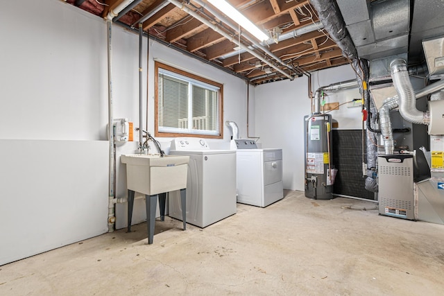 basement featuring independent washer and dryer, sink, and water heater