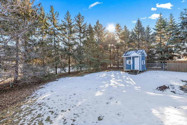 yard covered in snow featuring a storage shed