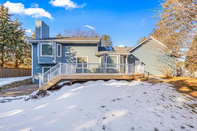 snow covered house with a deck